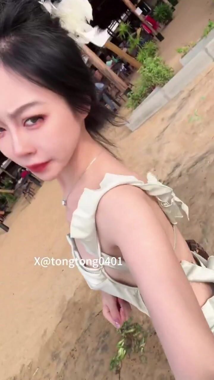 Dâm nữ xinh đẹp vừa đi dạo trên bãi biển vừa vạch áo show cặp vú nhỏ nhắn của mình